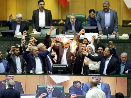 Iranian lawmakers burn two pieces of papers representing the U.S. flag and the nuclear deal as they chant slogans against the U.S. at the parliament in Tehran, Iran, Wednesday, May 9, 2018. Iranian lawmakers have set a paper U.S. flag ablaze at parliament after President Donald Trump's nuclear deal pullout, …