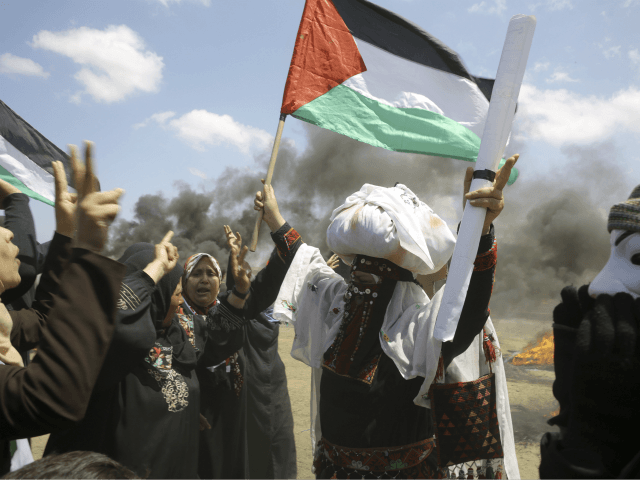 Palestinian women wave national flags and chant slogans near the Israeli border fence, east of Khan Younis, in the Gaza Strip, Monday, May 14, 2018. Thousands of Palestinians are protesting near Gaza's border with Israel, as Israel prepared for the festive inauguration of a new U.S. Embassy in contested Jerusalem. …