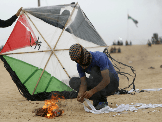 Palestinians prepare an incendiary device attached to a kite before trying to fly it over the border fence with Israel, on the eastern outskirts of Jabalia, on May 4, 2018. - Hundreds of Palestinians gathered on the Gaza border Friday for the sixth week of protests in which dozens have …