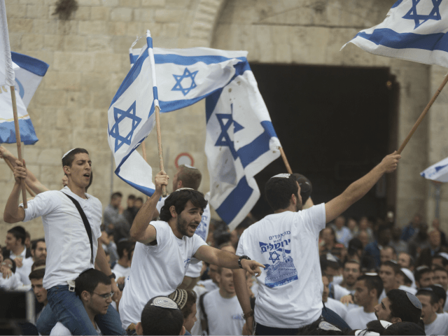 Israelis wave their national flags during a march outside Damascus Gate on May 13, 2018 in