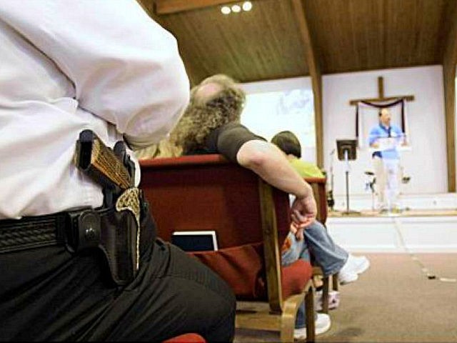 Cliff Meadows wears his firearm as he listens to pastor Ken Pagano during a service at the