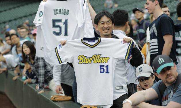 Fans hold Ichiro Suzuki jerseys from the Seattle Mariners and Orix BlueWave before a base