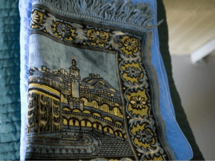 In this image reviewed by the U.S. Military, a traditional Muslim prayer rug sits folded n