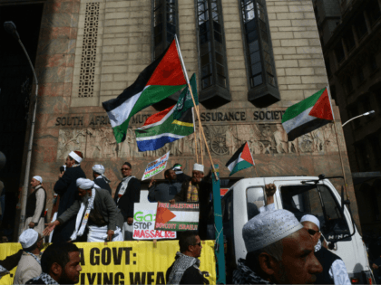 Muslims standing onto a truck, holding placards and waving Palestinian flags, take part to a demonstration in downtown Cape Town to protest Israel's military campaign in Gaza and show their support to the Palestinians people, on July 16, 2014. Israel urged 100,000 Gazans to flee their homes on July 16, …