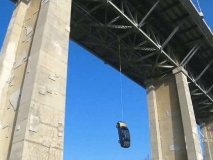 Toronto cops are left stumped by sight of blue sedan dangling by a rope from one of city's busiest bridges