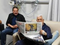 Palestinian Authority President Mahmoud Abbas shown recovering in hospital and reading a newspaper on the back page of which is a cartoon portraying an Israeli soldier poisoning a Palestinian baby, May 22, 2018. . (Wafa news agency)