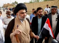 Iraqi Shiite cleric and leader Moqtada al-Sadr (C-L) outside a polling station in the central city of Najaf on May 12, 2018 Iraqi Shiite cleric and leader Moqtada al-Sadr (C-L) outside a polling station in the central city of Najaf on May 12, 2018