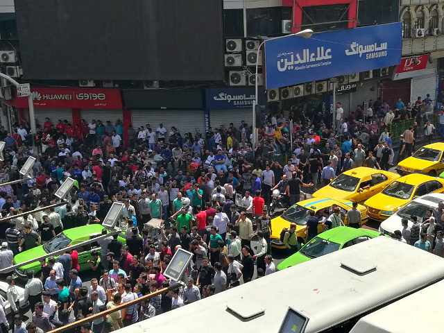 Iranian protesters shout slogans during a demonstration in central Tehran on June 25, 2018. - Traders in the Iranian capital's Grand Bazaar held a rare protest strike today against the collapse of the rial on the foreign exchange market as demonstrators also took to the streets. (Photo by ATTA KENARE …