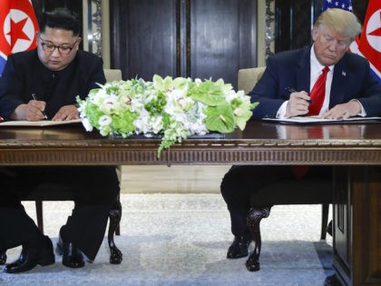 North Korea leader Kim Jong Un and U.S. President Donald Trump sign documents after their meetings at the Capella resort on Sentosa Island Tuesday, June 12, 2018 in Singapore. (AP Photo/Evan Vucci)