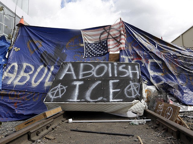 A barricade crosses railroad track at a protest camp on property outside the U.S. Immigration and Customs Enforcement office in Portland, Ore., Monday, June 25, 2018. Law enforcement officers began distributing notices to vacate to demonstrators late Monday morning. The round-the-clock demonstration outside the Portland headquarters began June 17, 2018, …