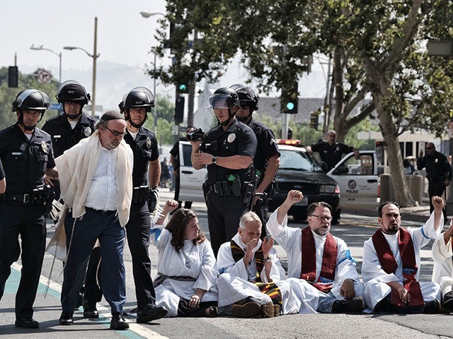 A member of clergy group, left, is arrested during a protest in front of Federal Courthouse in Los Angeles on Tuesday, June 26, 2018. Immigrant-rights advocates asked a federal judge to order the release of parents separated from their children at the border, as demonstrators decrying the Trump administration's immigration …
