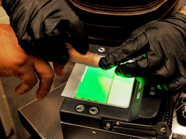 Border Patrol officials fingerprint an illegal alien as part of a biometric background check. (AP File Photo/Ross D. Franklin)