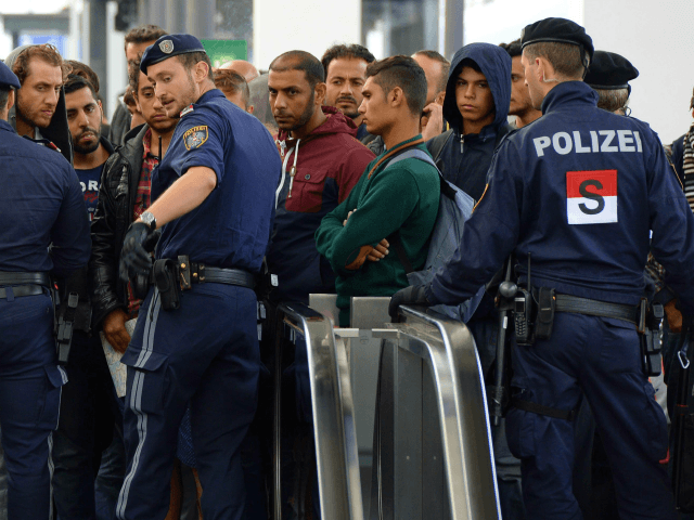 Police officers block refugees on a platform of the main train station in Salzburg, near t