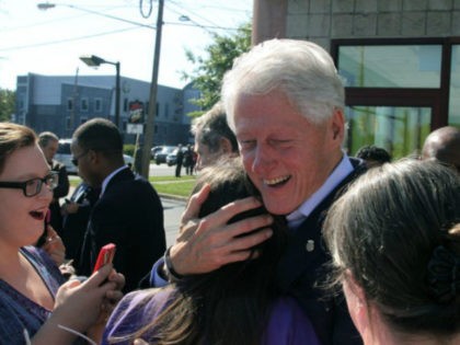 Former President Bill Clinton embraces newly registered voter Bethany Tomsich, as he campaigns on behalf of his wife Democratic presidential nominee Hillary Clinton, at the Western Reseve Building Trade Hall in Youngstown, Ohio. (Nikos Frazier/The Vindicator via AP)