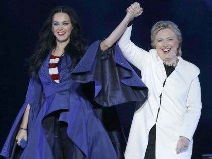 Katy Perry, left, holds the hand of Democratic presidential candidate, Hillary Clinton, right, during a concert at the Mann Center for the Performing Arts, Saturday, Nov. 5, 2016, in Philadelphia. (AP Photo/Julio Cortez)