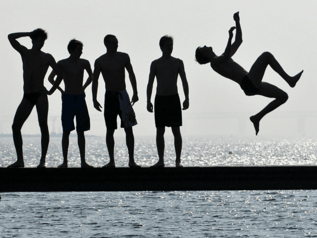 A boy jumps into the water on the first sunny spring day on April 2, 2011 in Malmo. The temperature in Malmo reached 17 degrees Celsius (63 degrees Fahrenheit), signalling the end of an unusually long and hard winter. AFP PHOTO/ SCANPIX/ JOHAN NILSSON ***SWEDEN OUT** (Photo credit should read …