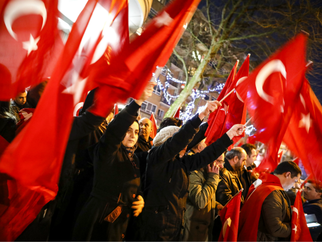 Dutch Turkish demonstrators hold Turkish flags as they gather outside the Turkish consulat