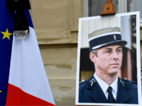 GettyImages-939054128 a portrait of French Lieutenant-Colonel Arnaud Beltrame is pictured during a minute of silence, on March 28, 2018 at the Interior Ministry in Paris. France honours during a national ceremony on March 28 a heroic policeman who died offering himself as a hostage in a jihadist attack. Beltrame, 44, was …