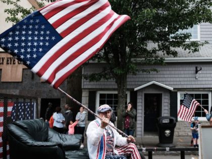 NAUGATUCK, CT - MAY 28: A man waves an American flag during the annual Memorial Day Parade on May 28, 2018 in Naugatuck, Connecticut. Across America, towns and cities will be remembering those who lost their lives while serving in the United States Armed Forces. Memorial Day is a federal …