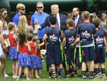 US President Donald Trump (C) interacts with children as people participate in the White House Sports and Fitness Day on May 30, 2018 in Washington,DC. (Photo by Nicholas Kamm / AFP) (Photo credit should read NICHOLAS KAMM/AFP/Getty Images)