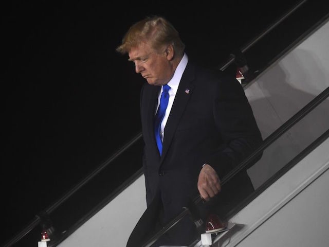 US President Donald Trump walks down the stairs after Air Force One arrived at Paya Lebar Air Base in Singapore on June 10, 2018 ahead of his planned meeting with North Korea's leader. - Kim Jong Un and Donald Trump will meet on June 12 for an unprecedented summit in …