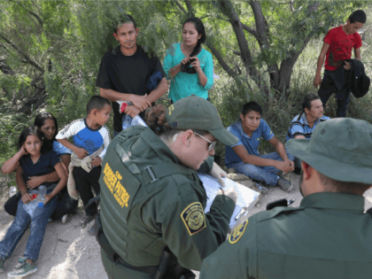 Central American asylum seekers wait as U.S. Border Patrol agents take groups of them into custody on June 12, 2018 near McAllen, Texas. The families were then sent to a U.S. Customs and Border Protection (CBP) processing center for possible separation. U.S. border authorities are executing the Trump administration's zero …