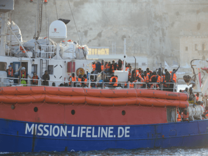 Migrants arrive aboard 'Lifeline', a vessel for the German charity Mission Lifeline, in the harbour of Valletta, Malta, on June 27, 2018. - A rescue boat stranded for nearly a week in the Mediterranean with over 200 migrants docked in Malta on June 27, 2018, after a deal was struck …