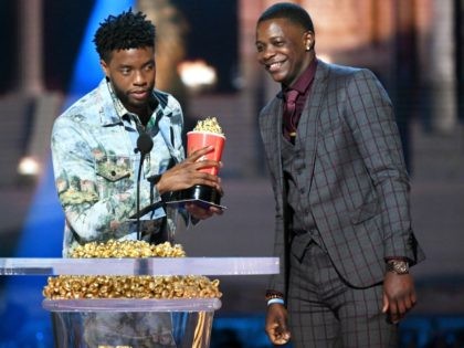 Actor Chadwick Boseman (L), winner of the Best Hero award for 'Black Panther,' presents his trophy to James Shaw Jr. onstage during the 2018 MTV Movie And TV Awards at Barker Hangar on June 16, 2018 in Santa Monica, California. (Photo by Kevin Winter/Getty Images for MTV)