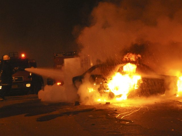 Egyptian firemen try to put out a fire on a vehicle following a car bombing in front of a