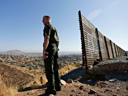 In this June 13, 2013 file photo, US Border Patrol agent Jerry Conlin looks out over Tijuana, Mexico, by the old border wall along the US - Mexico border, where it ends at the base of a hill in San Diego. U.S. Customs and Border Protection has begun testing body-worn …