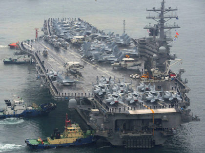 The USS Ronald Reagan aircraft carrier is escorted into Busan port, South Korea, after com