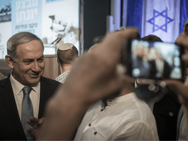 Israeli Prime Minister Benjamin Netanyahu talks with a visitor at the opening of an exhibition showcasing the 1976 Israeli commando rescue raid that freed hostages from a hijacked plane at Entebbe, Uganda, as he attends the event at the Yitzhak Rabin Center in Tel Aviv, Israel, Thursday, July 9, 2015. …
