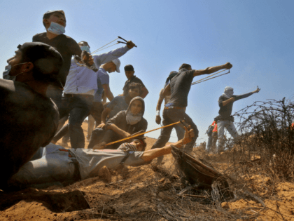 Hamas Palestinian protesters use slingshots to hurl stones toward Israeli forces during clashes near the border with Israel, east of Khan Yunis in the southern Gaza Strip on June 8, 2018. (Photo by SAID KHATIB / AFP) (Photo credit should read SAID KHATIB/AFP/Getty Images)