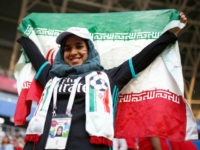 A female Iranian fan holds up her country's flag as she waits for the start of the group B match between Iran and Portugal at the 2018 soccer World Cup at the Mordovia Arena in Saransk, Russia, Monday, June 25, 2018. (AP Photo/Francisco Seco)