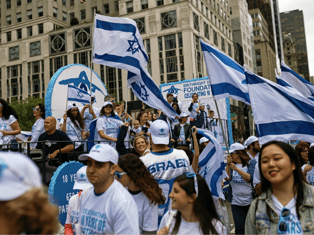 People carry Israeli flags as they march during the annual Celebrate Israel Parade, Sunday