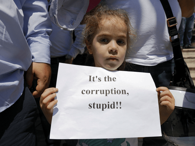 A Jordanian child holds a sign during an anti-austerity rally, on June 6, 2018 in Amman. -