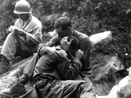 An American soldier comforts a fellow infantryman whose close friend has been killed in ac