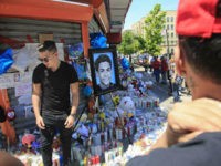 memorial-Bronx-teen-Lesandro-Guzman-Feliz-gang-crime-AP Celebrity artist Samil Alva, left, steps over candles after placing a portrait he painted of 15-year-old Lesandro Guzman-Feliz at a community memorial in New York on Tuesday June 26, 2018. The teenager was killed at the bodega last Wednesday in a machete attack. "I want my painting to bring love, …