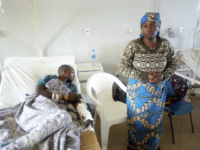 A woman stands near her relative as he receives treatment at the Jos University teaching hospital in Jos, Nigeria, Monday, June 25, 2018, after clashes in central Nigeria between mostly Muslim herders and Christian farmers. Dramatic footage from Jos showed angry people waving machetes and sticks and shouting at passing …