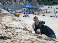 plastic pollution A participant takes part in a beach clean-up on Hong Kong's outlying Lamma island on May 27, 2018. - More than two thousand volunteers hit the beach on an outlying island of Hong Kong for a mass rubbish clean-up on May 27 as environment campaigners warned plastic is killing sea …