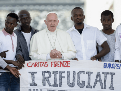 Pope Francis poses for a photo with a group of refugees he invited to join him on the step