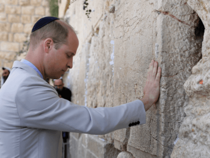 Britain's Prince William touches the Western Wall, the holiest site where Jews can pray, in Jerusalem's Old City on June 28, 2018. - The Duke of Cambridge is the first member of the royal family to make an official visit to the Jewish state and the Palestinian territories. (Photo by …