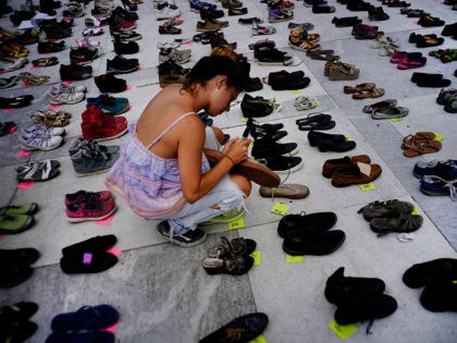 A woman places one of the hundreds of shoes in memory of those killed by Hurricane Maria in front of the Puerto Rico Capitol, in San Juan, Friday, June 1, 2018. Puerto Rico's Institute of Statistics announced that it has sued the U.S. territory's health department and demographic registry seeking …