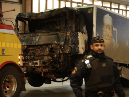 A destroyed truck is pull away by a service car after it was driven into a department store in Stockholm, Sweden, Saturday, April 8, 2017. The hijacked beer truck plowed into pedestrians at the central Stockholm department store on Friday, sending screaming shoppers fleeing in panic in what Sweden's prime …