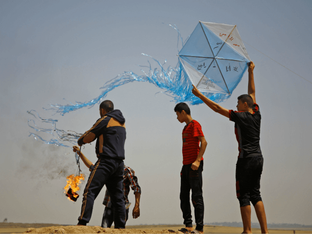 Palestinian protestors prepare to fly a kite loaded with an incendiary during a demonstration along the border with Israel east of Jabalia in the central Gaza Strip on June 8, 2018. - Palestinians in the besieged coastal enclave have used kites carrying burning cans to set ablaze Israeli fields, torching …