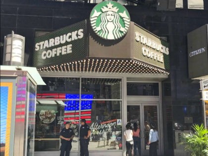 People peek inside a closed Starbucks Coffee Co. outlet near Times Square in New York on May 29, 2018. The company closed over 8,000 stores in the United States for the afternoon to conduct racial-bias training for its employees following an incident involving two African-American men at its shop in …