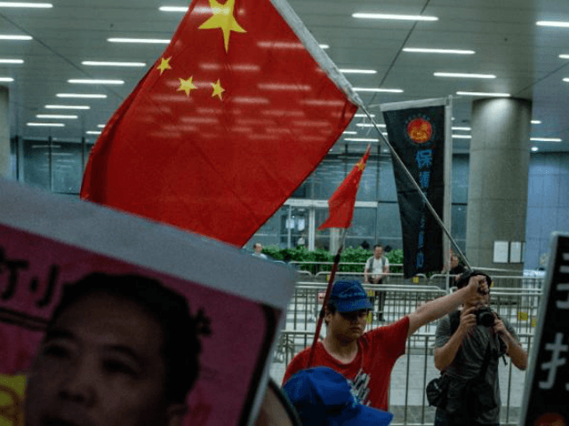 A Pro-Beijing protester (back centre) holds a Chinese flag during the anti-rail link rally