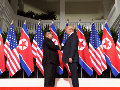 North Korea's leader Kim Jong Un (L) shakes hands with US President Donald Trump (R) at the start of their historic US-North Korea summit, at the Capella Hotel on Sentosa island in Singapore on June 12, 2018. - Donald Trump and Kim Jong Un have become on June 12 the …