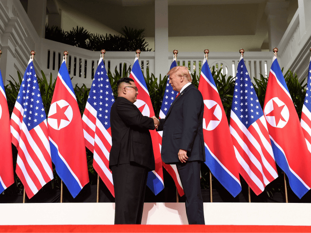 North Korea's leader Kim Jong Un (L) shakes hands with US President Donald Trump (R) at th