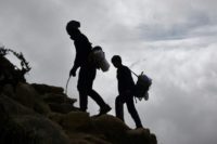 Nepalese porters walk up a path high above the north-eastern town of Namche Bazar, as they head to pick up goods from a town at a higher elevation